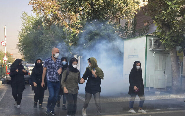 Illustration : Des manifestants fuyant les gaz lacrymogènes des services de sécurité devant l'université de Téhéran, en Iran, le 1er octobre 2022. (Crédit : AP Photo)