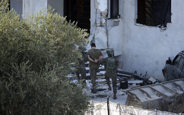 Des soldats israéliens arrêtent un Palestinien suspecté de terrorisme lors d’un raid dans le village de Deir al-Hatab, près de la ville de Naplouse, en Cisjordanie, le 5 octobre 2022 (Crédit : AP Photo/Majdi Mohammed)