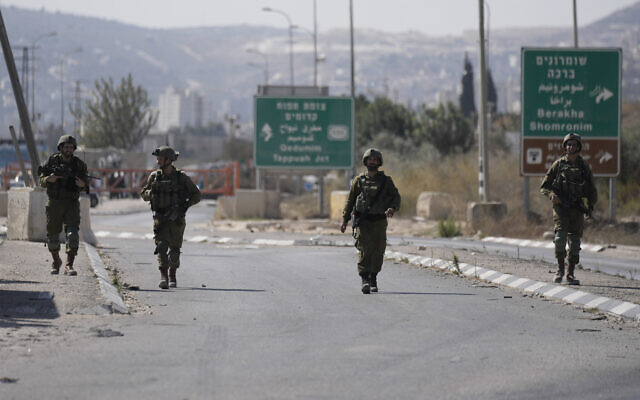 Des soldats israéliens bloquent le poste de contrôle de Hawara, l'entrée principale de la ville de Naplouse en Cisjordanie, le 12 octobre 2022. (Crédit : AP Photo/Majdi Mohammed)