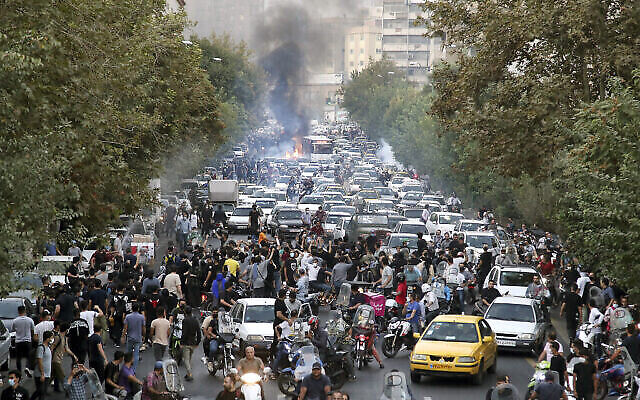 Des manifestants scandent des slogans lors d’une manifestation en réaction à la mort en détention d’une femme interpelée par la police des mœurs, dans le centre-ville de Téhéran, en Iran, le 21 septembre 2022. (Crédit : AP Photo)