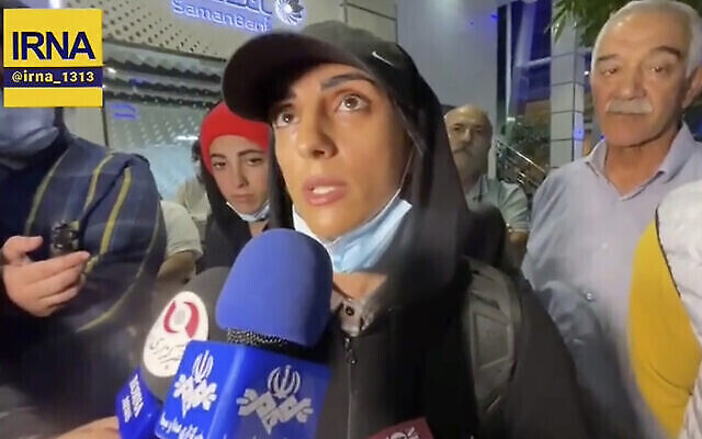 La grimpeuse iranienne Elnaz Rekabi s’entretenant avec des journalistes à l’aéroport international Imam Khomeiny, à Téhéran, en Iran, le 19 octobre 2022. (Crédit : IRNA via AP)