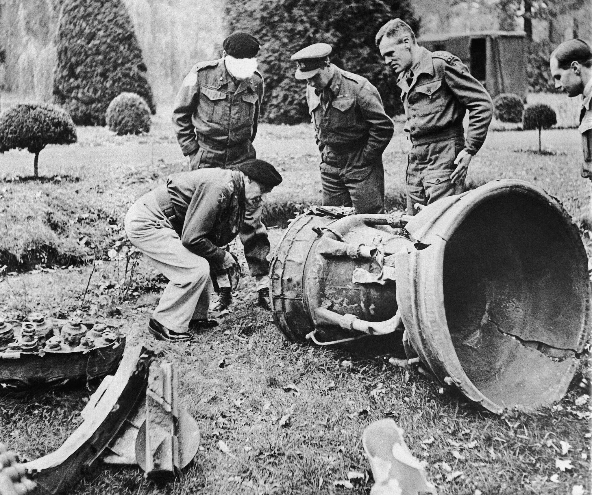 Des officiers britanniques examinent une roquette V2 retombée dans un champ en Belgique, le 4 décembre 1944. (Crédit : AP Photo)