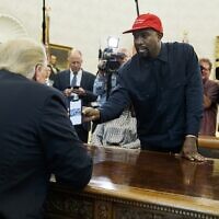 Le rappeur Kanye West montrant au président Donald Trump une photographie d'un avion à hydrogène lors d'une réunion dans le bureau ovale de la Maison Blanche, à Washington, le 11 octobre 2018. (Crédit : AP Photo/Evan Vucci)