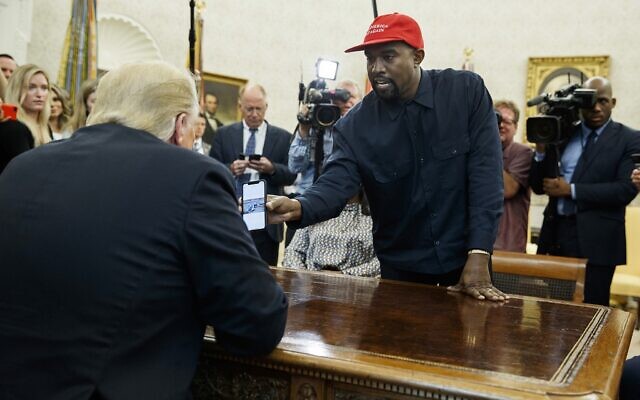 Le rappeur Kanye West montrant au président Donald Trump une photographie d'un avion à hydrogène lors d'une réunion dans le bureau ovale de la Maison Blanche, à Washington, le 11 octobre 2018. (Crédit : AP Photo/Evan Vucci)