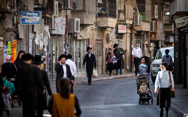 Des hommes et des femmes haredi marchent dans le quartier de Mea Shearim à Jérusalem, le 23 septembre 2020. (Crédit : Yonatan Sindel/Flash90)