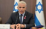 Le Premier ministre Yair Lapid, portant un ruban rose pour la sensibilisation au cancer du sein, dirigeant la réunion hebdomadaire du cabinet au bureau du Premier ministre, à Jérusalem, le 2 octobre 2022. (Crédit : Amos Ben Gershon/GPO)