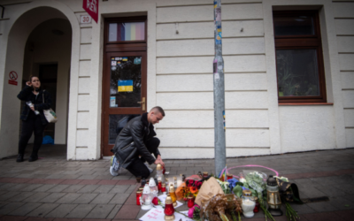 Un homme dépose une bougie sur un trottoir de la rue Zamocka, à Bratislava, après l'attentat commis par un "adolescent radicalisé", qui a coûté la vie à deux hommes, le 13 octobre 2022. (Crédit : Vladimir Simicek/AFP/Getty Images via la JTA)