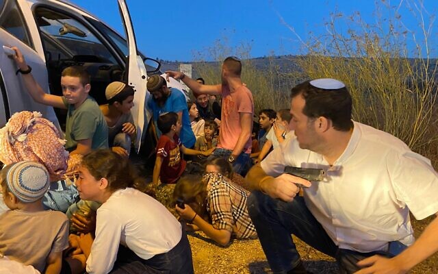 Le président du Conseil régional de Samarie, Yossi Dagan, et d'autres civils cachés derrière une voiture pendant des coups de feu à proximité de Naplouse, en Cisjordanie, le 2 octobre 2022. (Crédit : Conseil régional de Samarie)