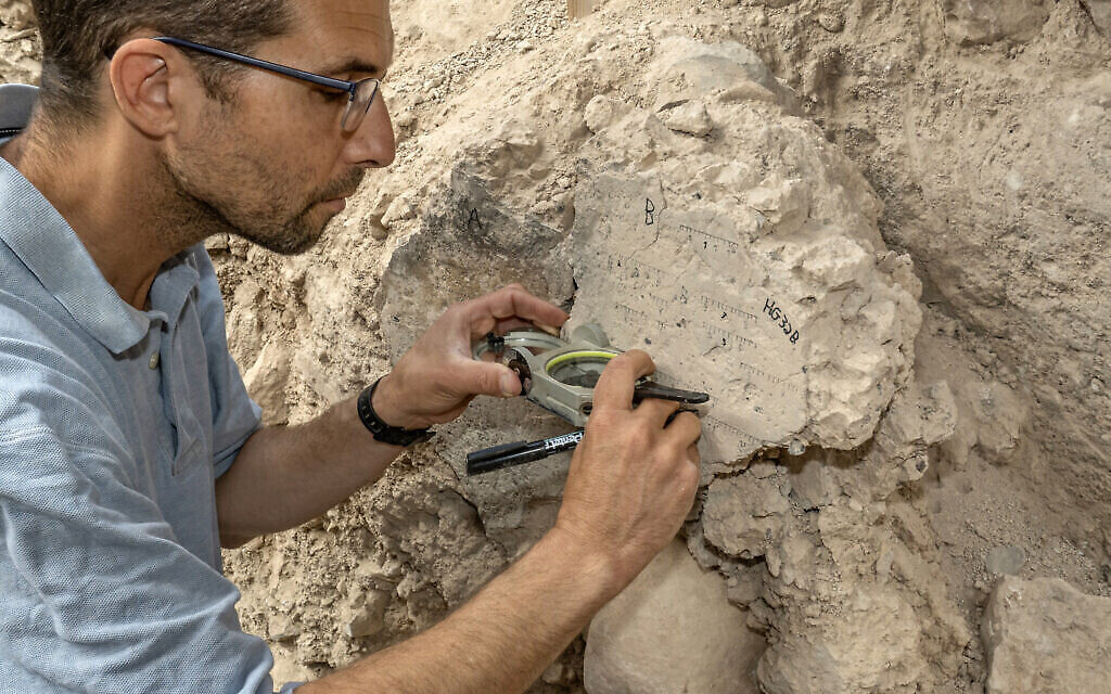 Yoav Vaknin, doctorant à l'université de Tel Aviv, prenant des mesures d'une couche de terre effondrée lors de la destruction de Jérusalem par les Babyloniens, en 586 avant notre ère. (Crédit : Shai Halevi/Autorité israélienne des Antiquités)