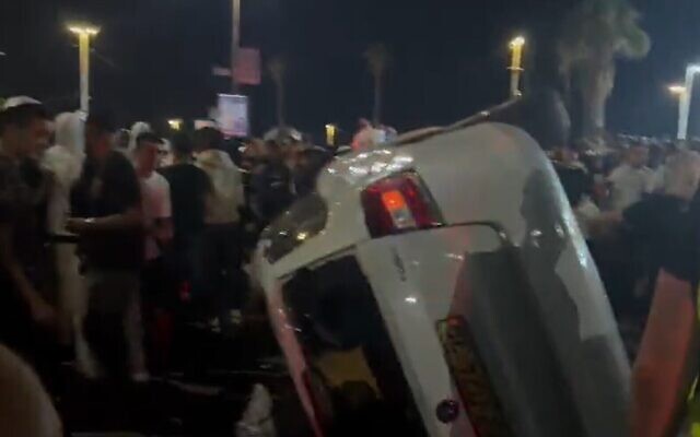 Une voiture retournée par une foule qui a attaqué le conducteur arabe et les passagers, à Bat Yam, le 4 octobre 2022. (Crédit : Capture d'écran utilisée conformément à la clause 27a de la loi sur le droit d'auteur)