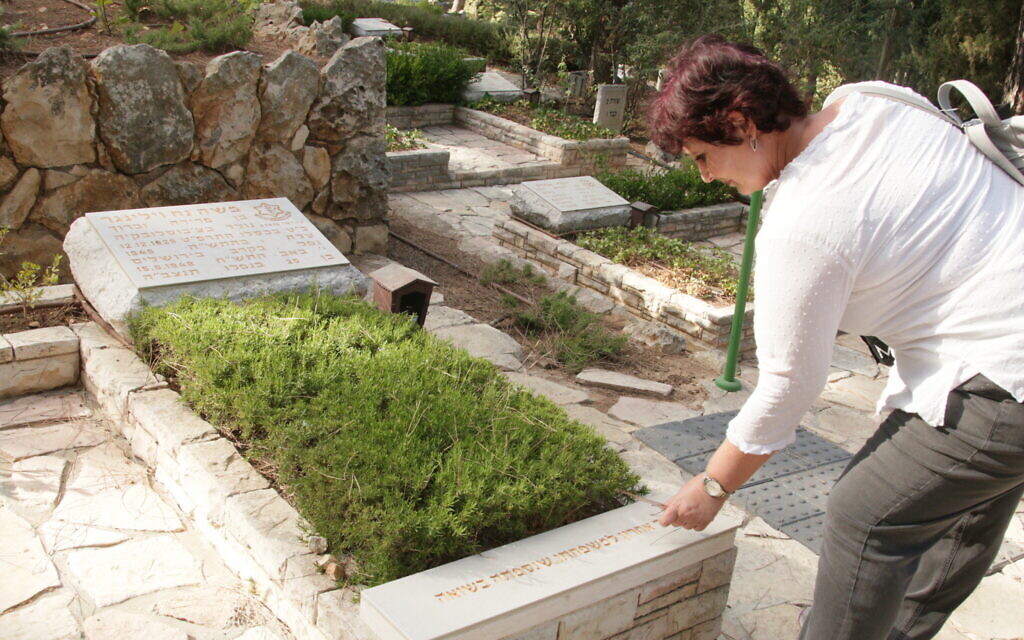 Dorit Perry, fondatrice de Giving a Face to the Fallen, se rendant sur la tombe de Moshe Wilinger. (Crédit : Shmuel Bar-Am)