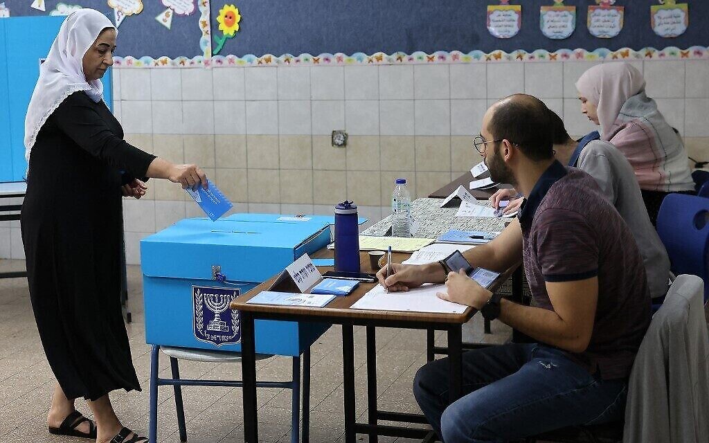 Une électrice arabe israélienne dépose son bulletin de vote dans un bureau de vote du village de Maghar, dans le nord d'Israël, le 1er novembre 2022. (Crédit : AHMAD GHARABLI / AFP)