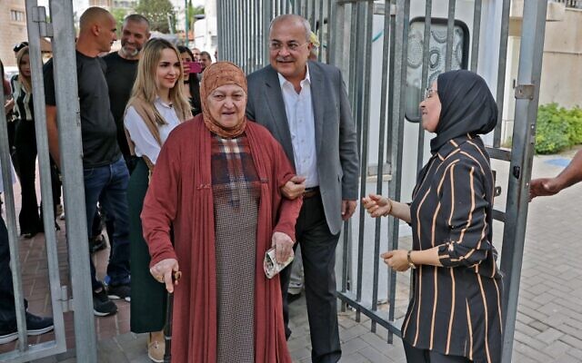 Ahmad Tibi, le chef du parti Taal, marchant avec sa mère après avoir voté aux élections législatives, dans la ville majoritairement arabe de Taybeh, le 1er novembre 2022. (Crédit : Ahmad Gharabli/AFP)