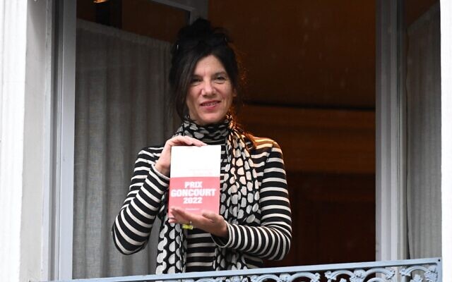 L'écrivain français Brigitte Giraud tient son roman à la fenêtre du restaurant Drouant après avoir reçu le prestigieux prix littéraire Goncourt pour son roman "Vivre Vite" (Flammarion) à Paris, le 3 novembre 2022. (Crédit : Bertrand GUAY / AFP)