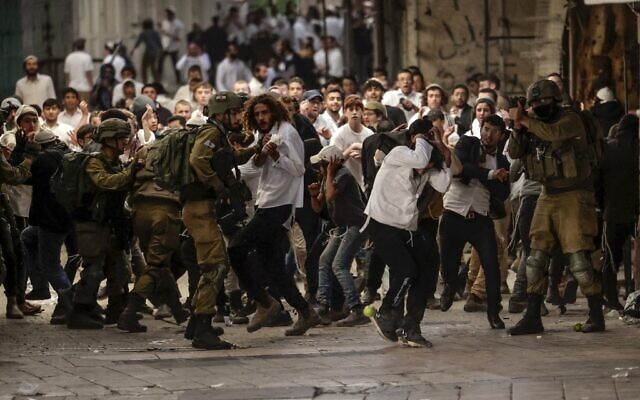 Les forces de sécurité israéliennes déployant des moyens de dispersion des émeutes au milieu d’altercations entre Israéliens et Palestiniens, alors qu’ils se rendent sur la tombe d’Othniel dans la ville de Hébron, en Cisjordanie, le 19 novembre 2022. (Crédit : Hazem Bader/AFP)