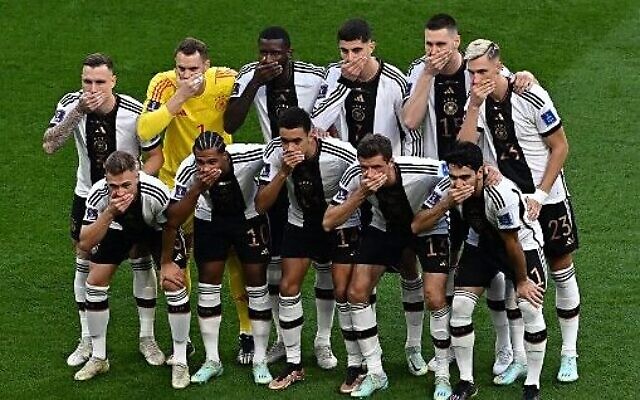 Les joueurs allemands se couvrent la bouche en posant pour une photo de groupe pendant un match de football du groupe E dans la Coupe du monde 2022 qui se déroule au Qatar, le 23 novembre 2022. (Crédit : Anne-Christine POUJOULAT / AFP)