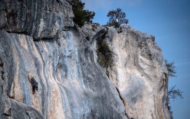 L'alpiniste et activiste Daniel Kufner escalade un itinéraire nommé "Forteresse Europe" dans le parc naturel de Hohe Wand, près de Wiener Neustadt en Basse-Autriche, le 8 octobre 2022.  (Crédit : VLADIMIR SIMICEK / AFP)