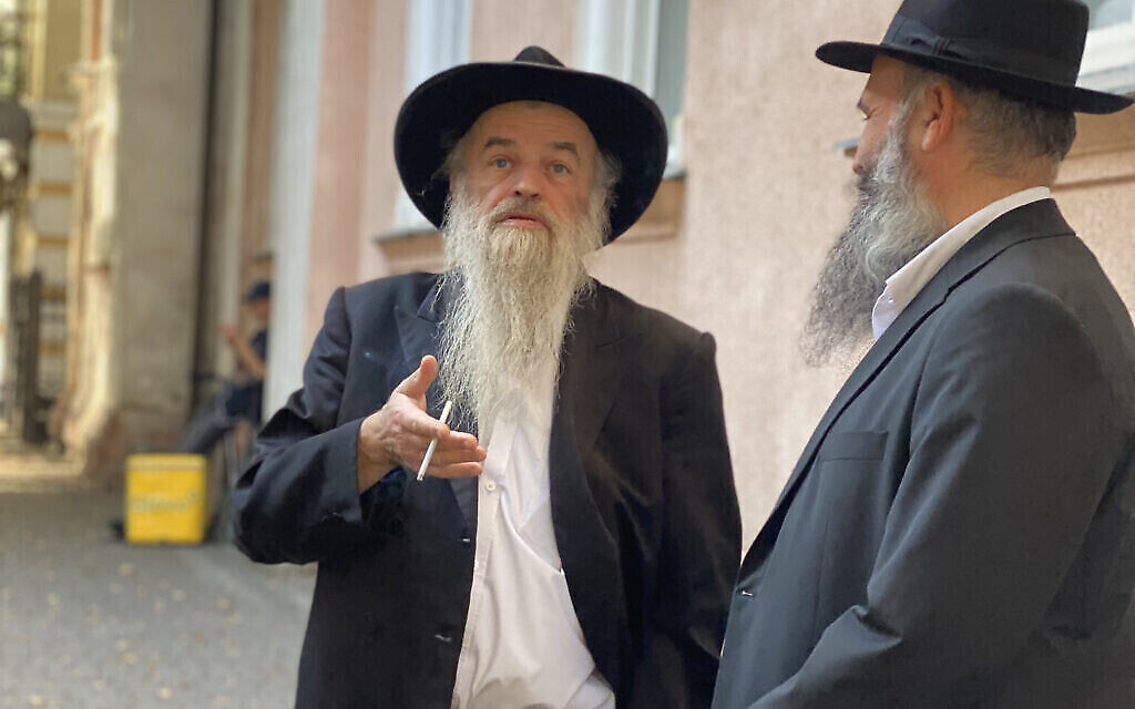 Le rabbin d’Ivano-Frankivsk, Moyshe Kolesnik, fume une cigarette devant sa synagogue avec un rabbin ukrainien de passage. Depuis l’invasion russe, des villes comme Lviv et Ivano-Frankivsk sont devenues un carrefour pour les juifs ukrainiens qui entrent et sortent du pays. (Crédit : Jacob Judah / JTA)