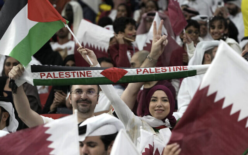 Des supporters agitent le drapeau palestinien et applaudissent avant le match de la Coupe du monde de football entre le Qatar et l'Équateur au stade Al Bayt à Al Khor, le 20 novembre 2022. (Crédit : Ariel Schalit/AP)