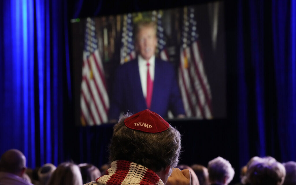 Des personnes écoutent l'ancien président Donald Trump s'exprimer à distance lors d'une réunion annuelle des dirigeants de la Coalition juive républicaine, samedi 19 novembre 2022, à Las Vegas. (Crédit : John Locher/AP)