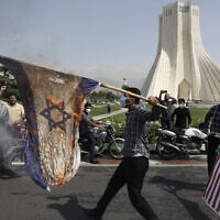 Des manifestants brûlent des représentations des drapeaux israéliens et américains pendant la Journée annuelle d'Al-Quds (Jérusalem) à Téhéran, le 7 mai 2021. (Crédit : AP Photo/Vahid Salemi)