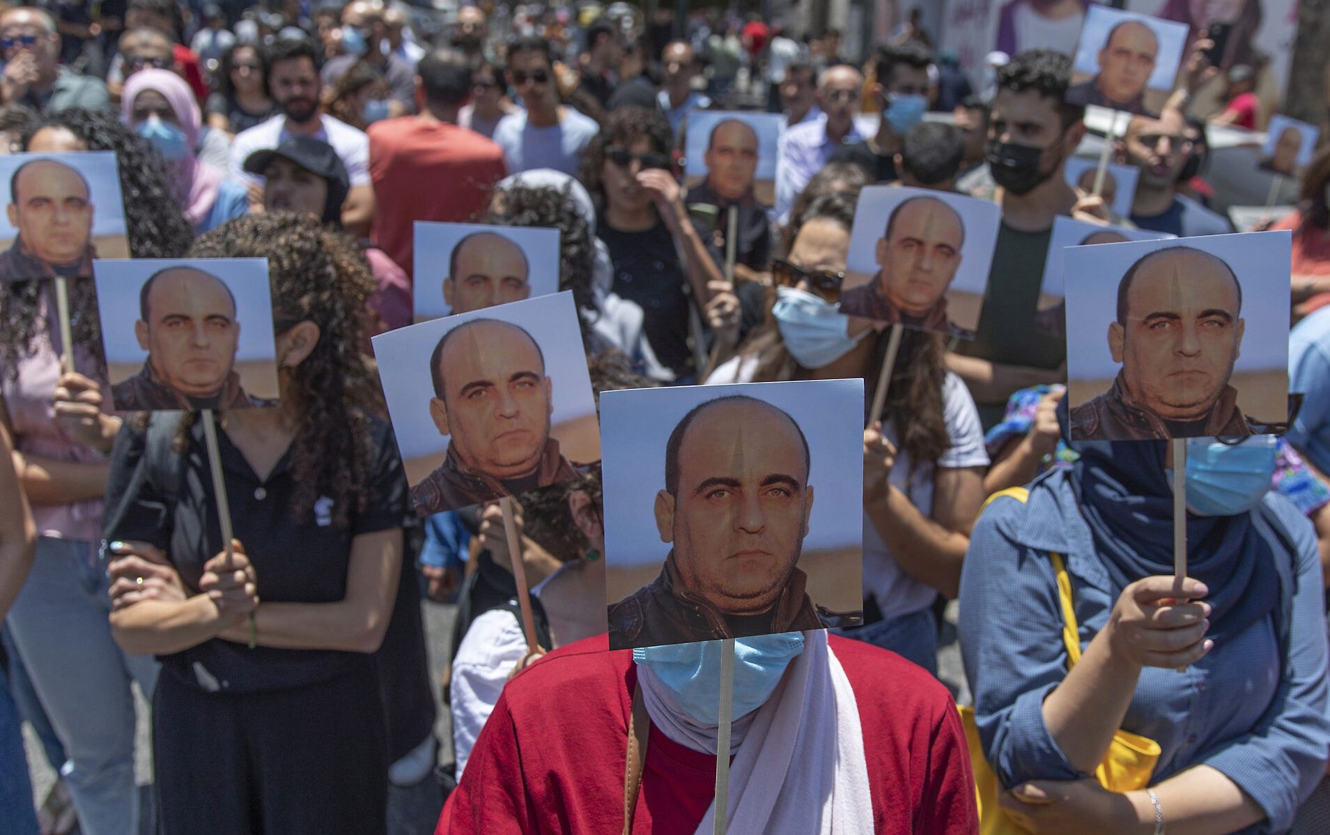 Des manifestants avec des photos de Nizar Banat, critique de l'Autorité palestinienne, pendant un rassemblement dénonçant sa mort à Ramallah, en Cisjordanie, le 24 juin 2021. (Crédit : AP Photo/Nasser Nasser)