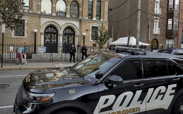 Des policiers font le guet à l'extérieur de la synagogue de Hoboken, dans le New Jersey, le 3 novembre 2022, après que le FBI a mis en garde contre une "large menace" visant les lieux de culte juifs dans l'État. (Crédit : AP/Ryan Kryska)
