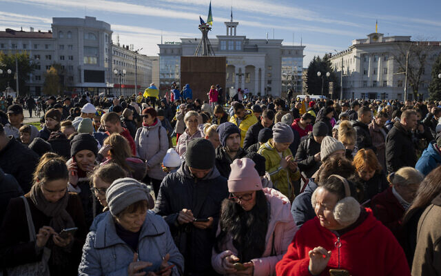 Des habitants se rassemblent près d'un point d'accès à Internet à Kherson, dans le sud de l'Ukraine, lundi 14 novembre 2022. (Crédit : AP Photo/Bernat Armangue)