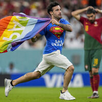 Un homme court sur le terrain de foot avec un drapeau arc-en-ciel lors du match de la Coupe du monde entre le Portugal et l'Uruguay, au stade Lusail, au Qatar, le lundi 28 novembre 2022. (Crédit : AP/Abbie Parr)