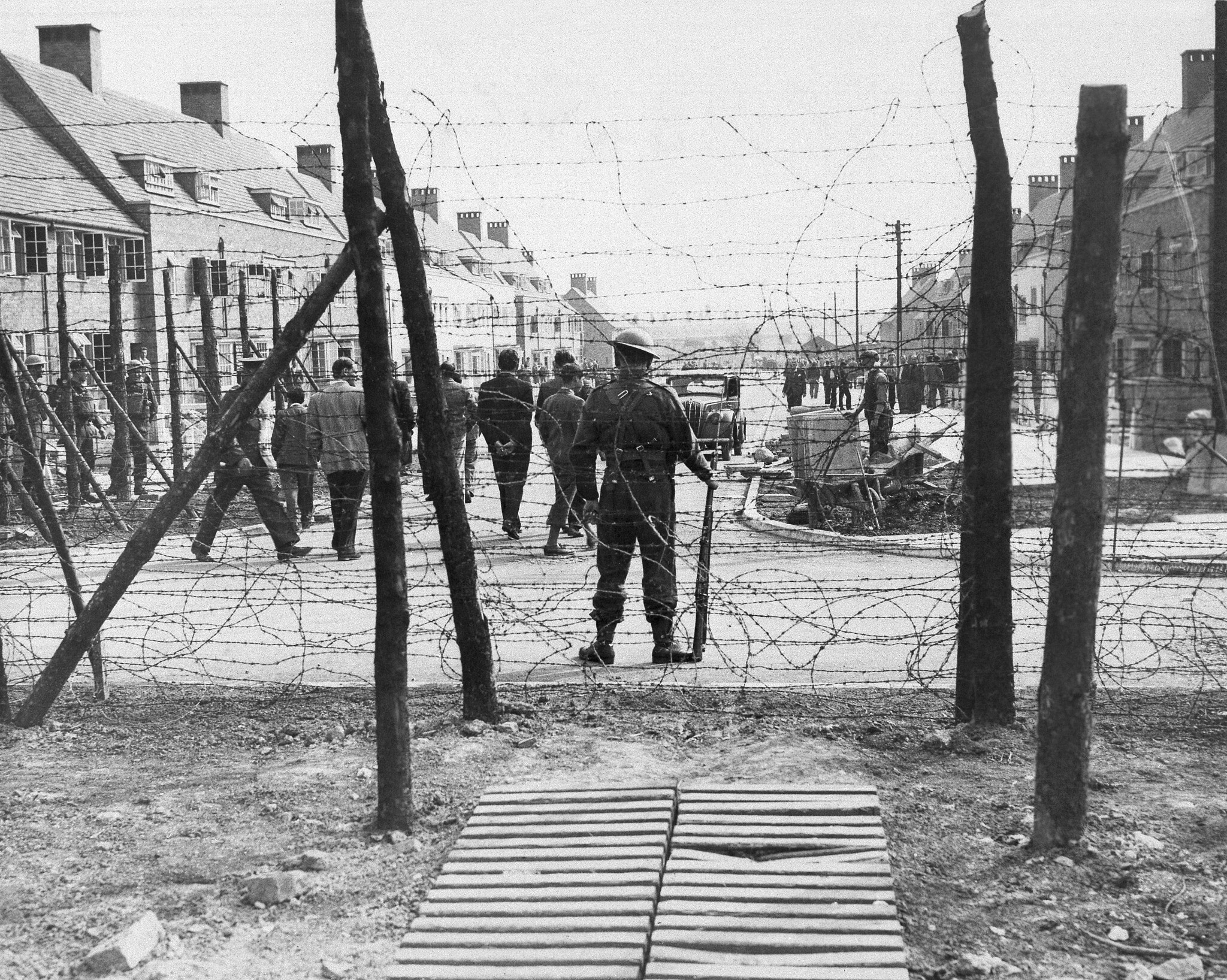 Une sentinelle armée monte la garde dans un camp d'internement des "ennemis étrangers"  en Angleterre, le 2 juin 1940. (Crédit : AP)