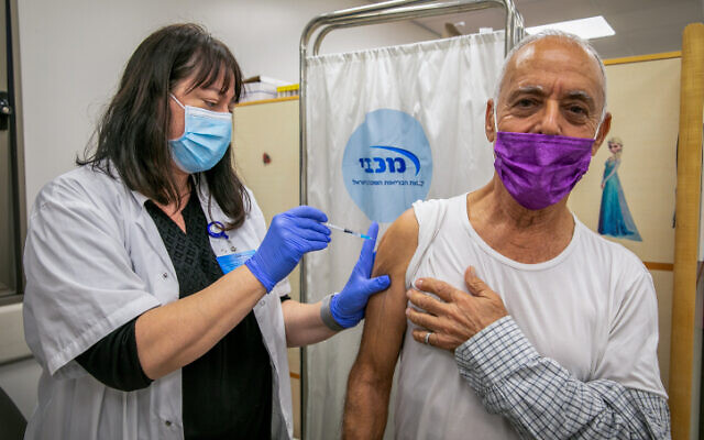 Un Israélien recevant une dose du vaccin contre la COVID-19 peu après l'introduction des quatrièmes doses, au centre de vaccination Maccabi à Modiin, le 6 janvier 2022. (Crédit : Yossi Aloni/Flash90)
