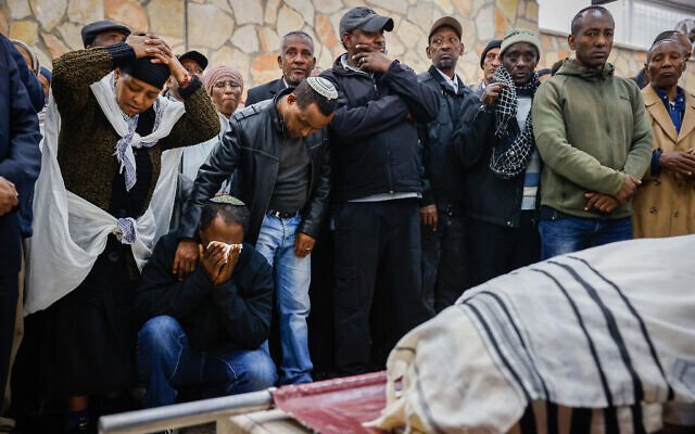 La famille et les amis assistant aux funérailles de Tadese Tashume Ben Maada, qui a succombé à ses blessures lors du double-attentat à la bombe à l'entrée de Jérusalem, au cimetière Har HaMenuchot, à Jérusalem, le 27 novembre 2022. (Crédit : Olivier Fitoussi/Flash90)