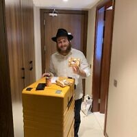 Eli Chitrik, 21 ans, tenant un bagel casher mis gratuitement à la disposition des fans juifs qui assistent à la Coupe du monde à Doha, au Qatar, le 23 novembre 2022. (Crédit : Ash Obel/The Times of Israel)