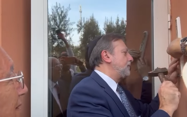 Le rabbin principal du Conseil juif des Émirats, Elie Abadie, accrochant une mézouza à la synagogue Beit El de l'université polytechnique Mohammed VI de Marrakech, au Maroc. (Crédit : YouTube)