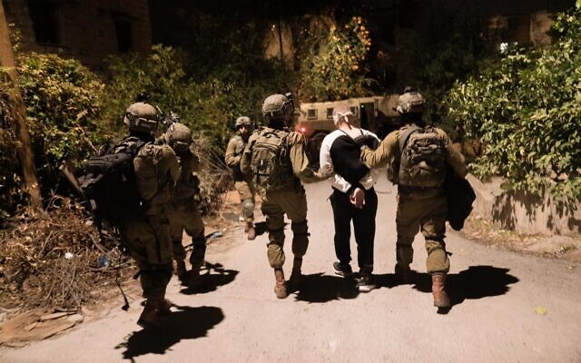 Les troupes israéliennes arrêtant un Palestinien recherché lors d'un raid en Cisjordanie, tôt le 12 novembre 2022. (Crédit : Armée israélienne)