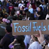 FILE - Un panneau disant "Les néergies fossiles dehors" pendant une manifestation au sommet sur le climat de l'ONU de la COP27 à Sharm el-Sheikh, en Égypte, le 12 novembre 2022. (Crédit :  AP Photo/Peter Dejong, File)