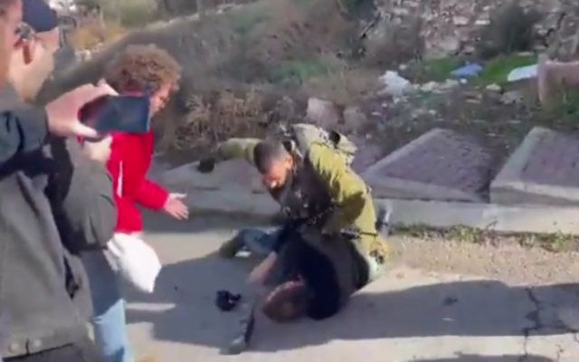 Un soldat israélien frappe un activiste de gauche à Hébron, en Cisjordanie, le 25 novembre 2022. (Crédit : Breaking the Silence)