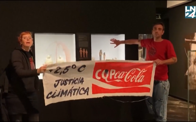Deux jeunes activistes, un homme et une femme appartenant au collectif "Futuro Vegetal", ont aspergé à l'aide de bouteilles en plastique de Coca-Cola la cage en verre de faux pétrole, puis les murs de faux sang, afin de dénoncer l'inaction des gouvernements réunis pour la COP27 en Egypte face au changement climatique, à Madrid, le 14 novembre 2022. (Capture d'écran Twitter)