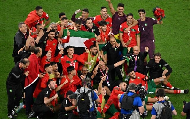 Les joueurs du Maroc célèbrent avec un drapeau palestinien à la fin du match de football des huitièmes de finale de la Coupe du monde Qatar 2022 entre le Maroc et l'Espagne au stade Education City à Al-Rayyan, à l'ouest de Doha, le 6 décembre 2022. (Crédit : Glyn KIRK / AFP)