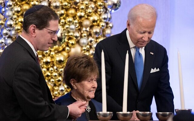 Le rabbin Charlie Cytron-Walker et le président américain Joe Biden avec une survivante de la Shoah, Bronia Brandman, pendant la réception donnée pour la fête de Hanoukka à la Maison Blanche, à Washington, le 19 décembre 2022. (Crédit : Brendan Smialowski / AFP)
