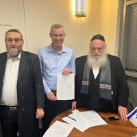 Les députés de Yahadout HaTorah Moshe Gafni (à gauche) et Yitzhak Goldknopf (à droite) signent un accord de coalition provisoire avec le négociateur du Likud Yariv Levin le 6 décembre 2022. (Crédit : Autorisation)