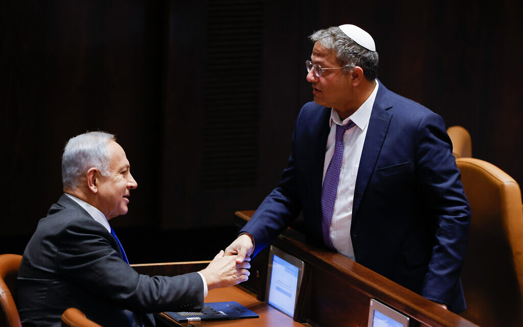 Le nouveau ministre de la Sécurité nationale, Itamar Ben Gvir, serre la main du nouveau Premier ministre Benjamin Netanyahu à la Knesset après un vote visant à étendre les pouvoirs ministériels de Ben Gvir, le 28 décembre 2022. (Crédit : Olivier Fitoussi/Flash90)