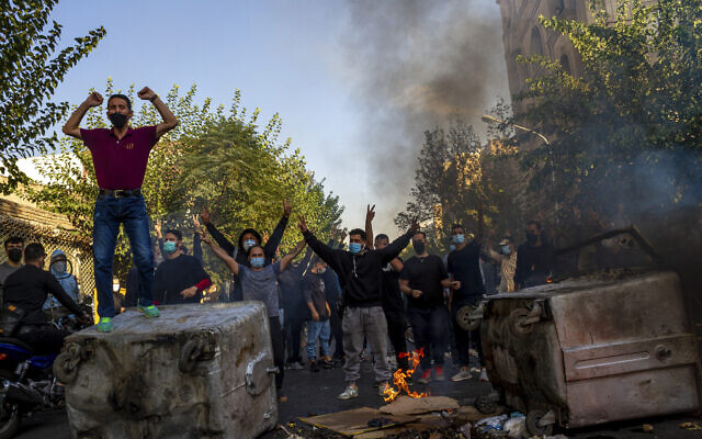 Sur cette photo prise par une personne non employée par l'Associated Press et obtenue par l'AP à l'extérieur de l'Iran, des Iraniens protestent contre la mort de Mahsa Amini, 22 ans, après son arrestation par la police des mœurs le mois dernier, à Téhéran, le 27 octobre 2022. (Crédit : AP Photo/Middle East Images)