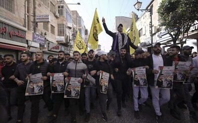 Des Palestiniens tiennent des posters du prisonnier palestinien Nasser Abu Hamid lors d'une manifestation, le 20 décembre 2022, à Ramallah, après qu'il est décédé d'un cancer du poumon en Israël. (Crédit : AP Photo/Majdi Mohammed)