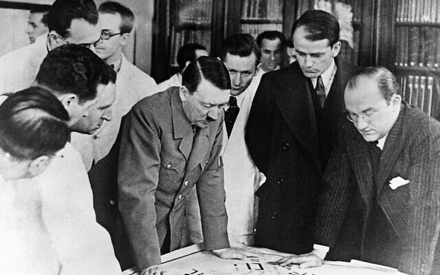 Adolf Hitler examine les plans des nouveaux bâtiments du parti à Nuremberg, à côté d'Albert Speer (deuxième à droite, qui regarde les dessins), le 24 février 1937. (Crédit : AP Photo)