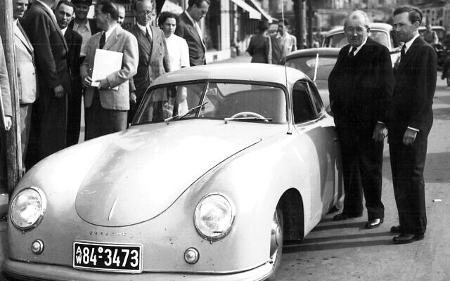 L'entrepreneur et concepteur automobile austro-allemand Ferdinand Porsche Jr, à droite, se tient avec son père Ferdinand à côté d'une voiture de sport Porsche, le 10 juin 1950. (Crédit : AP)
