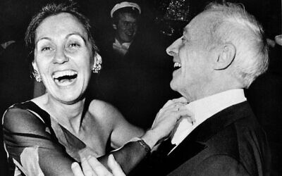 Le romancier Saul Bellow rit alors que son épouse, Alexandra, ajuste sa cravate lors d’un bal à l’hôtel de ville de Stockholm, en l’honneur des lauréats du prix Nobel, le 10 décembre 1976. Bellow a remporté le prix Nobel de littérature. (Crédit : AP)