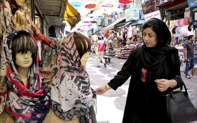 Une femme regarde un foulard sur un marché du centre-ville de Téhéran, en Iran, le 3 juillet 2019. (Crédit : AP Photo/Ebrahim Noroozi)