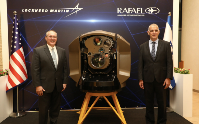 Frank St. John, directeur des opérations de Lockheed Martin, et Yoav Har-Even, PDG de Rafael, à côté d'un système de défense "Iron Beam", en Israël, le 5 décembre 2022. (Crédit : Lockheed Martin)