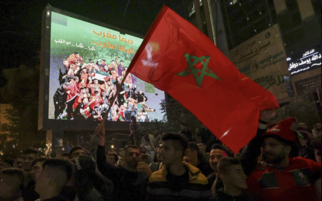 Des Palestiniens célébrant la victoire du Maroc sur le Portugal après le match de quart de finale de la Coupe du monde Qatar 2022 dans les rues de Hébron, en Cisjordanie, le 10 décembre 2022. (Crédit : Hazem Bader/AFP)